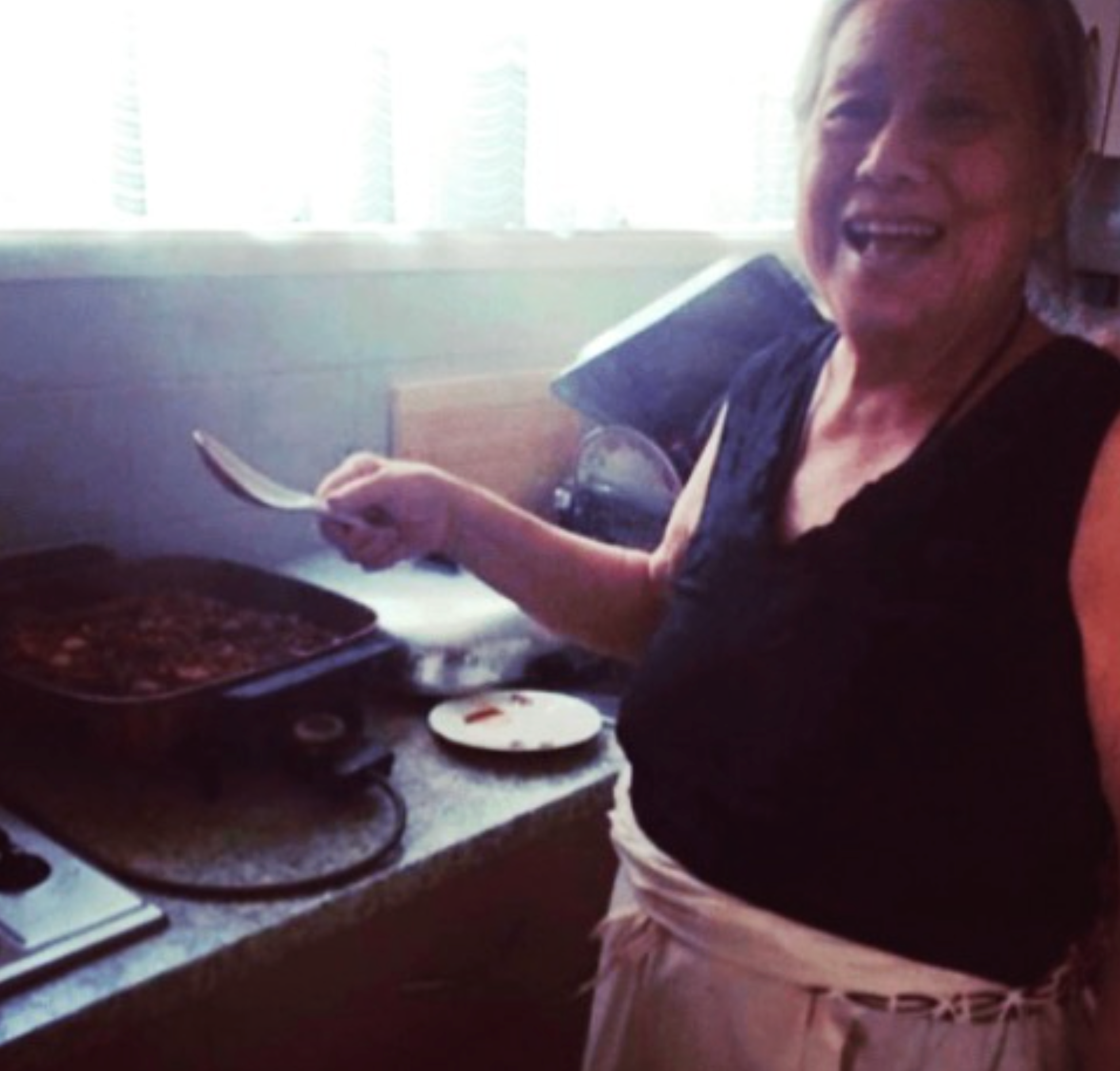 Photo of Nana Ō smiling in her kitchen, making delicious food for her family.